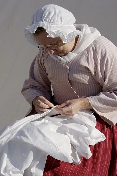 HOUS2D-00049. Woman reenactor sewing, Yorktown battlefield, Virginia.. Digital photograph