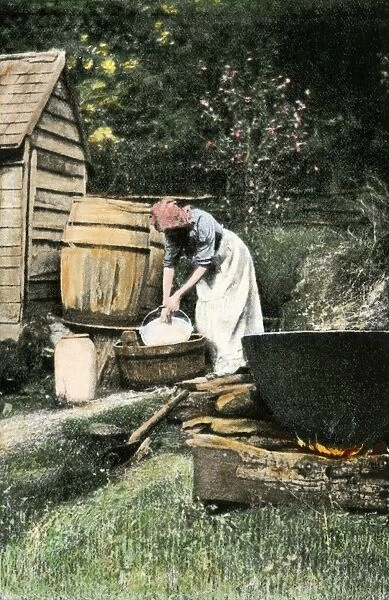 Making soap. Woman making soft soap by hand with an outdoor kettle to render lard.