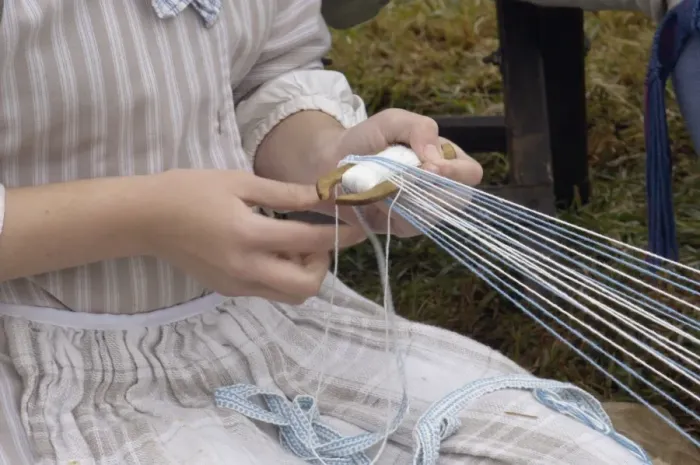 Framed Print : Reenactor weaving on a belt loom at a Revolutionary War reenactment