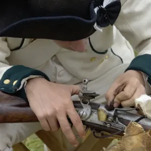 French soldier cleaning his musket at a reenactment on the Yorktown Battlefield French soldier cleaning his musket at a reenactment on the Yorktown Battlefield