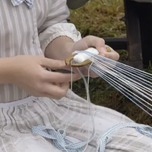 Reenactor weaving on a belt loom at a Revolutionary War reenactment Reenactor weaving on a belt loom at a Revolutionary War reenactment