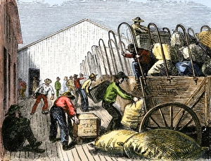 Pioneers loading supplies into wagons for travel across the prairies